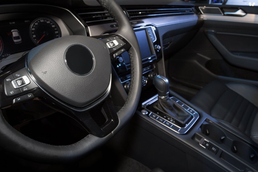 A car 's steering wheel and dashboard are shown.